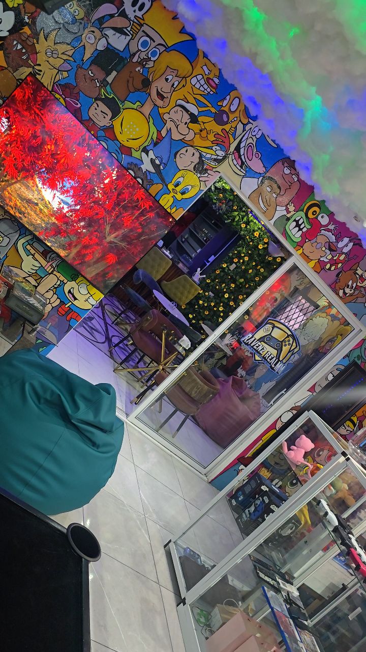 Cartoon Network mural above glass collectibles cabinets and a bean bag